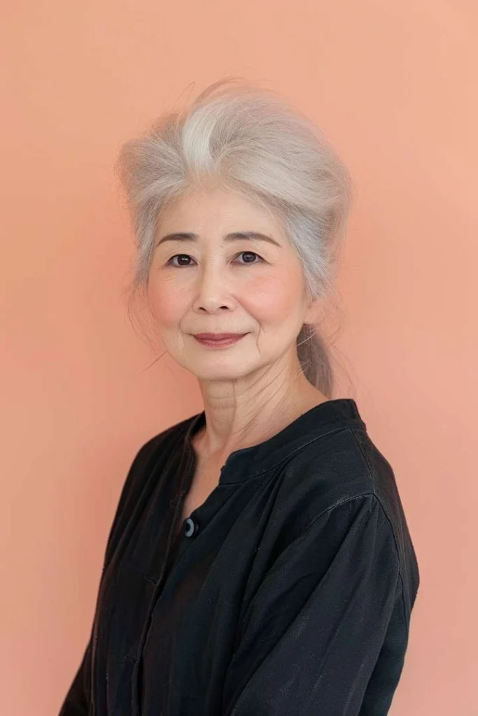 Woman over 60 with a soft undercut, a subtle yet bold medium length hairstyle for women over 60, styled with natural gray tones.